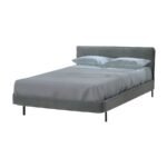 Vista angular en perspectiva de la cama Lyon de Scrivania con cabecera minimalista y base de metal negro mate.
