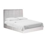 Cama de recámara moderna modelo Wisconsin tapizada en elegante tela de terciopelo premium, vista en perspectiva angular con colchón y sábanas blancas.